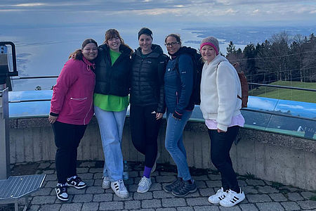 Fünf Frauen stehen auf einem Aussichtsplatz, im Hintergrund ist der Bodensee zu sehen.